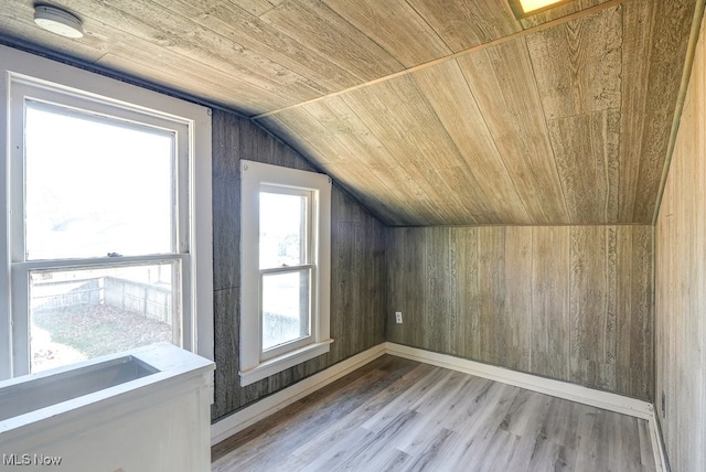 bonus room featuring wood ceiling, wood walls, wood-type flooring, and lofted ceiling