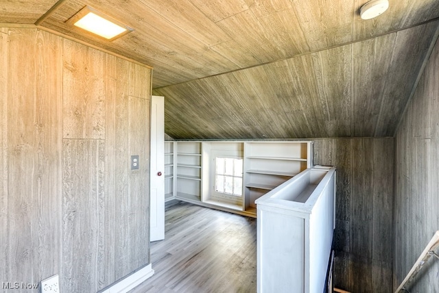 additional living space featuring vaulted ceiling, hardwood / wood-style flooring, wooden ceiling, washer / dryer, and wood walls