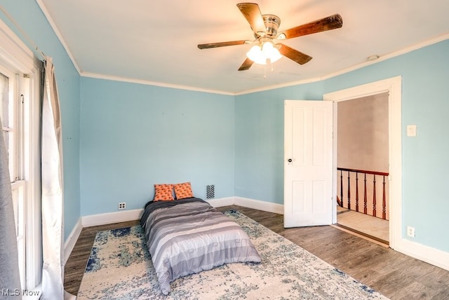 bedroom with ceiling fan, dark hardwood / wood-style flooring, and ornamental molding