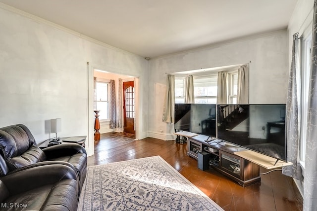 living room featuring a healthy amount of sunlight, crown molding, and dark wood-type flooring