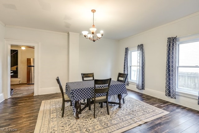 dining space with dark hardwood / wood-style floors, an inviting chandelier, and ornamental molding