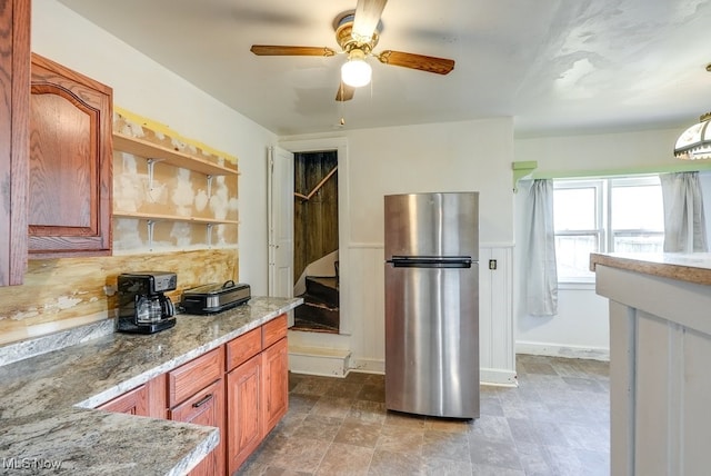 kitchen with decorative backsplash, stainless steel fridge, ceiling fan, and light stone countertops