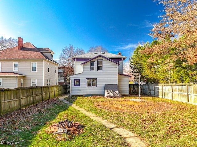 rear view of property featuring a lawn