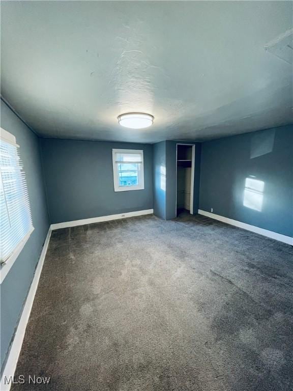 carpeted spare room featuring a wealth of natural light