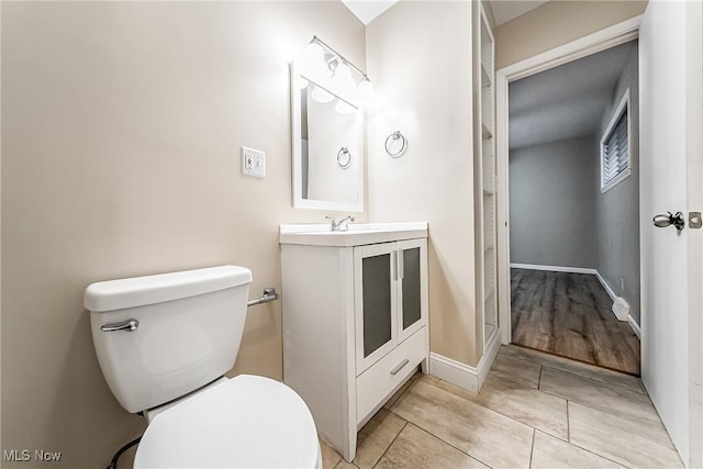 bathroom with vanity, hardwood / wood-style flooring, and toilet