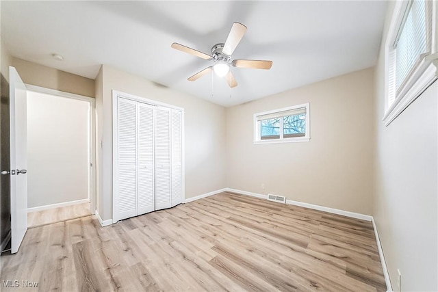 unfurnished bedroom featuring ceiling fan, light hardwood / wood-style flooring, and a closet