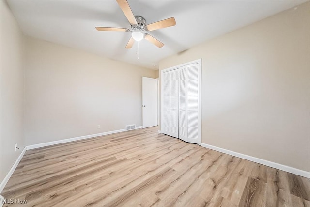 unfurnished bedroom featuring ceiling fan, a closet, and light hardwood / wood-style floors