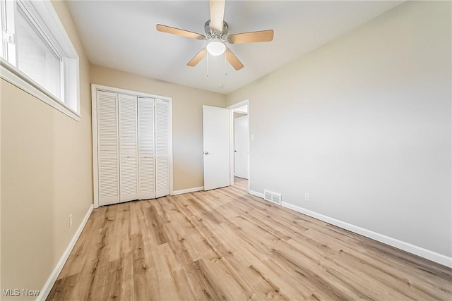 unfurnished bedroom with ceiling fan, a closet, and light hardwood / wood-style floors