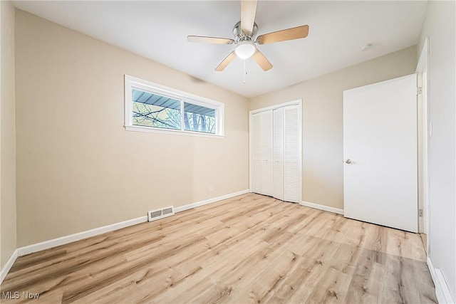 unfurnished bedroom featuring a closet, ceiling fan, and light hardwood / wood-style flooring