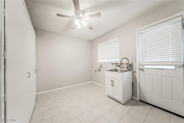 washroom with a textured ceiling, ceiling fan, light tile patterned floors, and sink