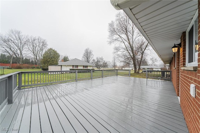 wooden deck featuring a lawn