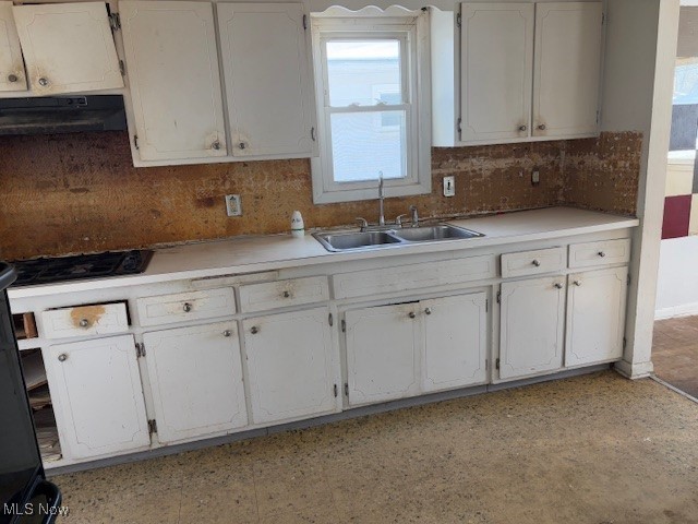 kitchen featuring black gas cooktop, exhaust hood, white cabinets, sink, and decorative backsplash