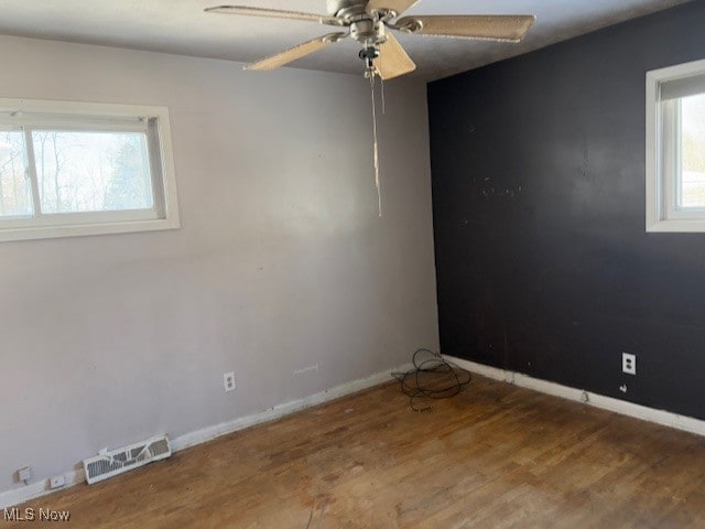 unfurnished room with hardwood / wood-style flooring, ceiling fan, and a healthy amount of sunlight