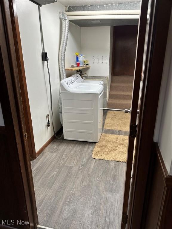 laundry room featuring light hardwood / wood-style floors and washing machine and clothes dryer