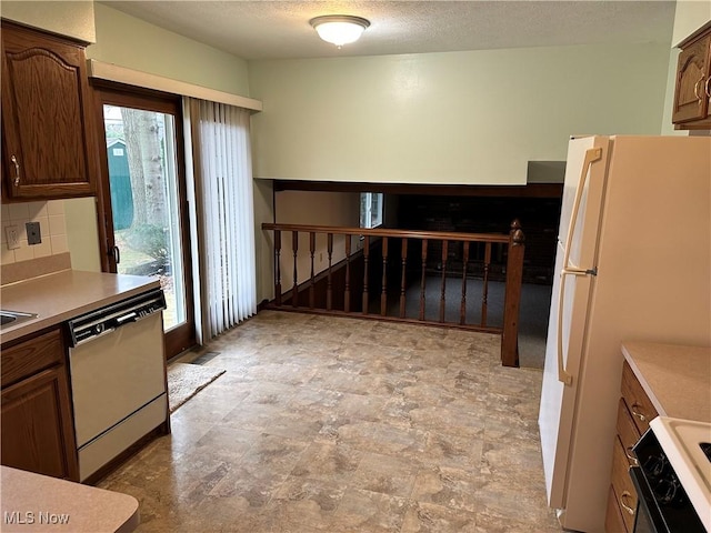 kitchen featuring decorative backsplash, stainless steel dishwasher, a textured ceiling, range, and white fridge