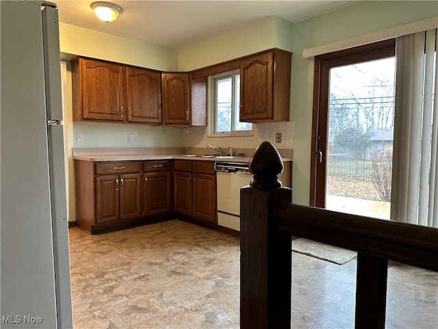 kitchen with dishwasher, refrigerator, tasteful backsplash, and a healthy amount of sunlight