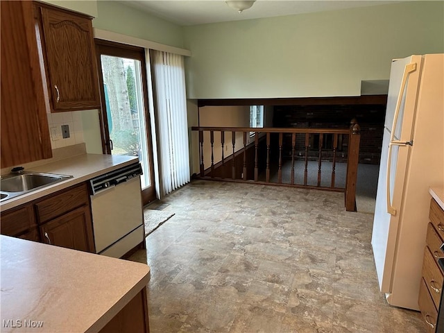 kitchen featuring tasteful backsplash, sink, and white appliances