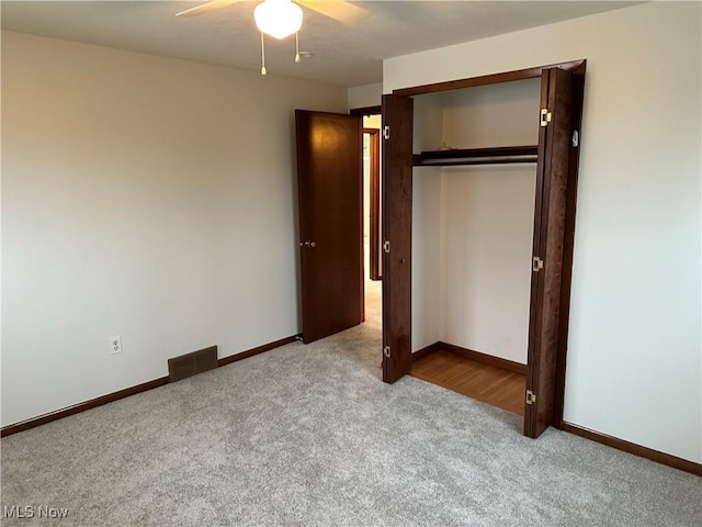 unfurnished bedroom featuring ceiling fan, light carpet, and a closet