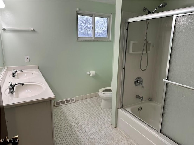 full bathroom featuring shower / bath combination with glass door, tile patterned floors, vanity, and toilet