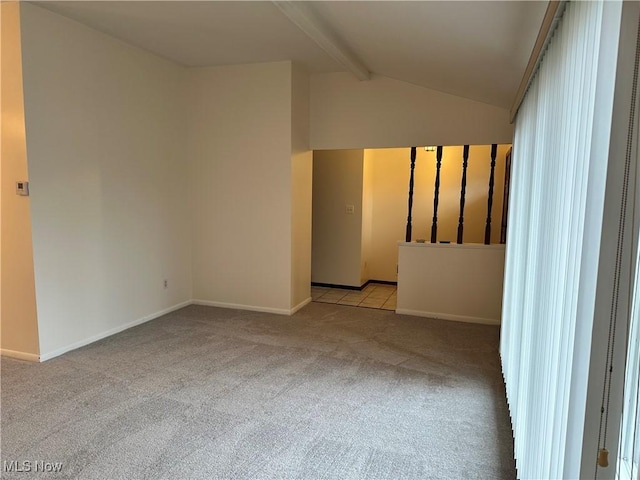 carpeted spare room featuring lofted ceiling with beams