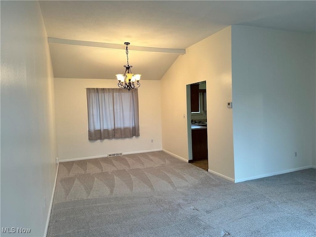 carpeted spare room featuring vaulted ceiling and a chandelier