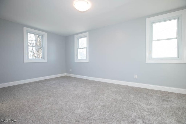 empty room featuring carpet flooring and plenty of natural light