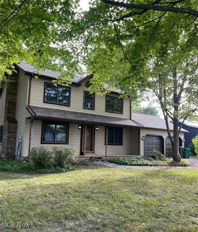 view of front of house with a front yard and a garage