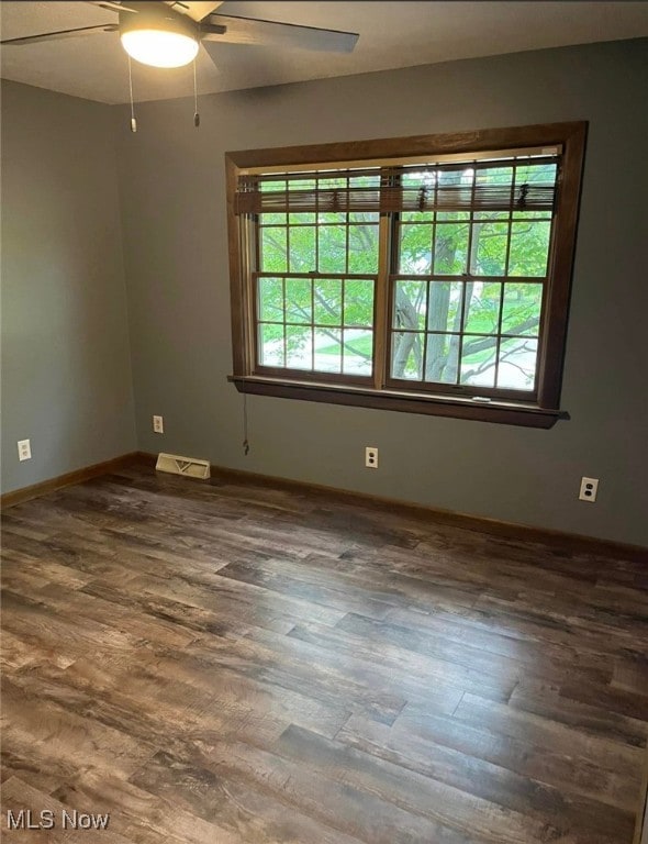 empty room featuring dark hardwood / wood-style floors and ceiling fan