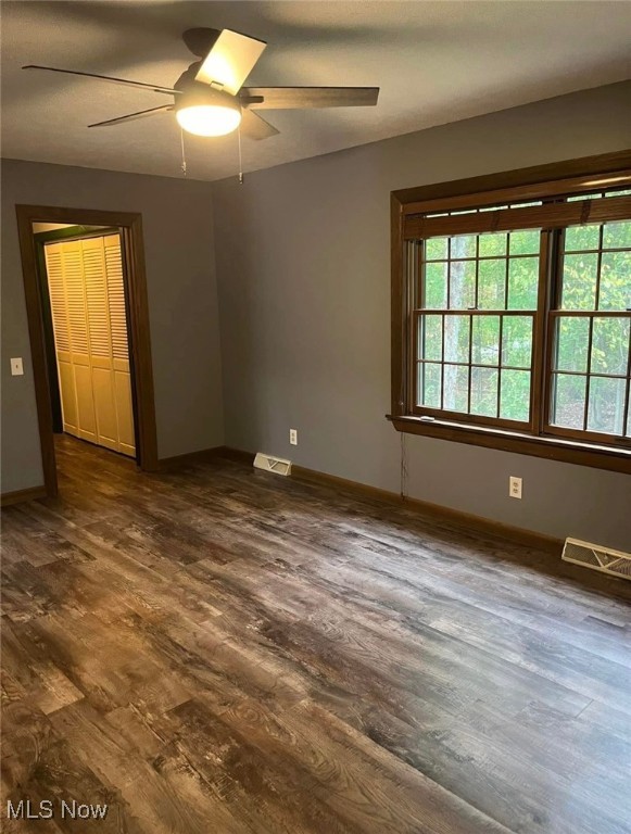 unfurnished room with dark hardwood / wood-style floors and ceiling fan