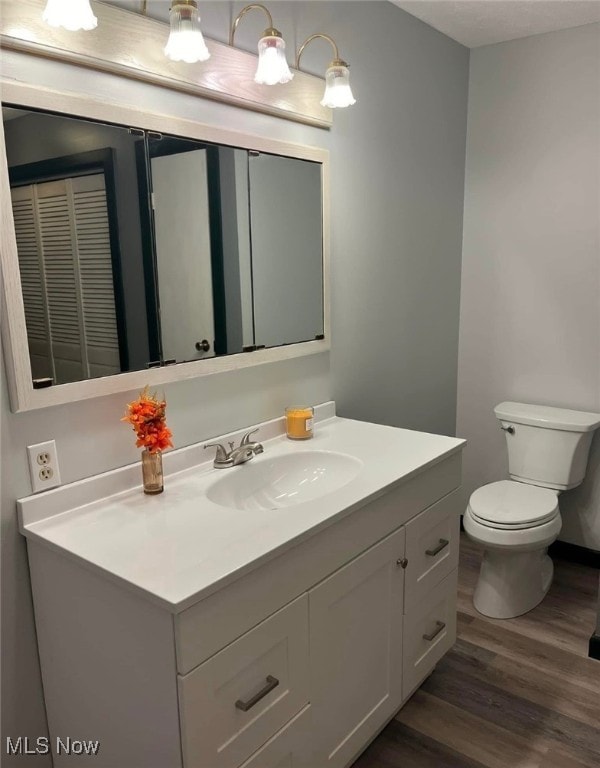 bathroom featuring hardwood / wood-style flooring, vanity, and toilet