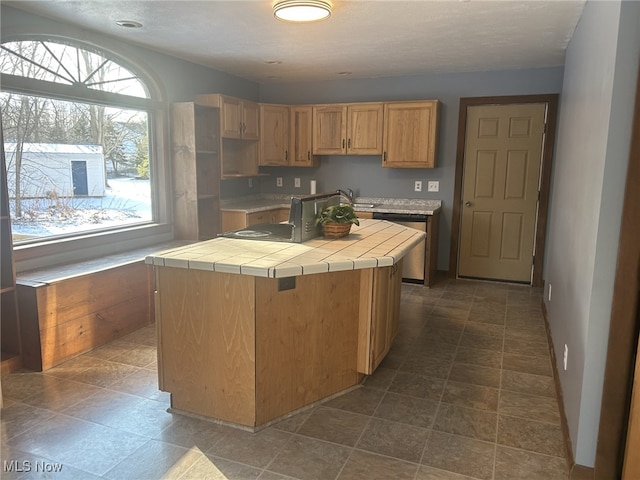 kitchen featuring tile countertops, a center island, a textured ceiling, and sink