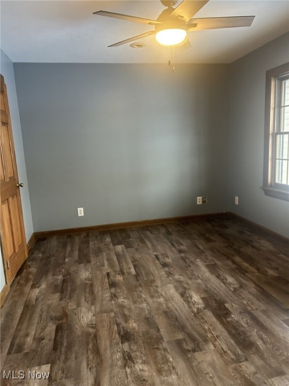 spare room with ceiling fan and dark hardwood / wood-style floors