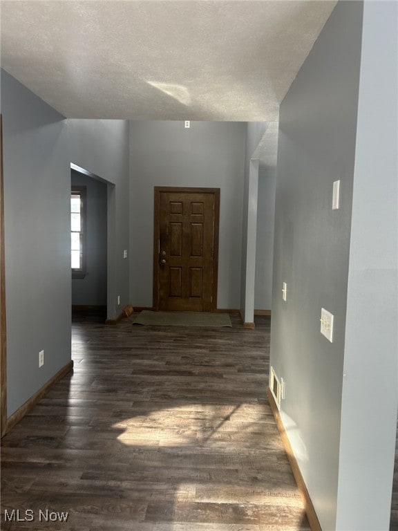 foyer featuring a textured ceiling and dark hardwood / wood-style floors