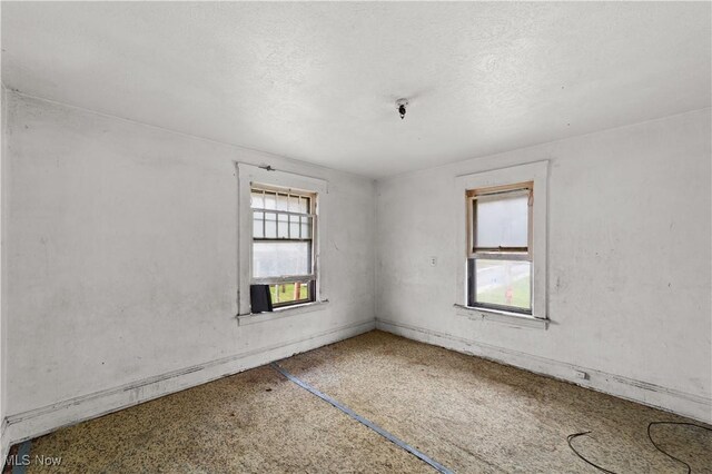 unfurnished room featuring a textured ceiling