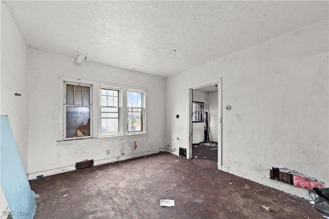 unfurnished room featuring a textured ceiling