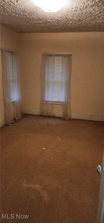 spare room featuring plenty of natural light and a textured ceiling