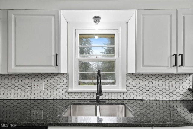 kitchen with white cabinets, tasteful backsplash, and sink