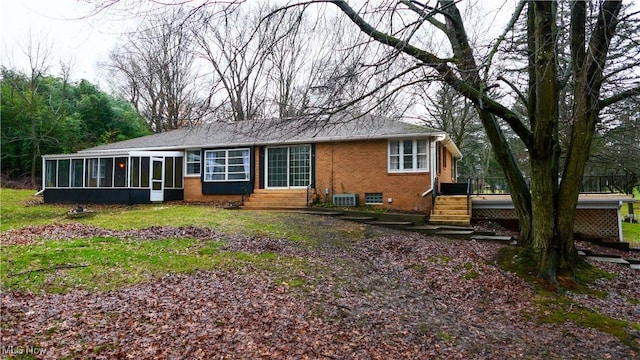 view of front of house with central air condition unit, a wooden deck, and a sunroom