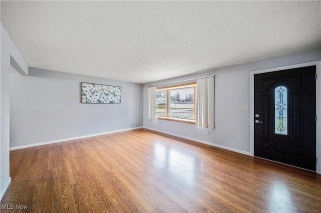 entrance foyer with hardwood / wood-style flooring and a textured ceiling