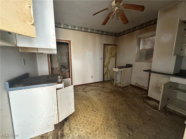 kitchen featuring a ceiling fan and baseboards