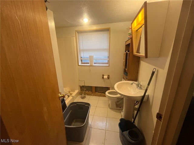 bathroom with sink, tile patterned flooring, a textured ceiling, and toilet