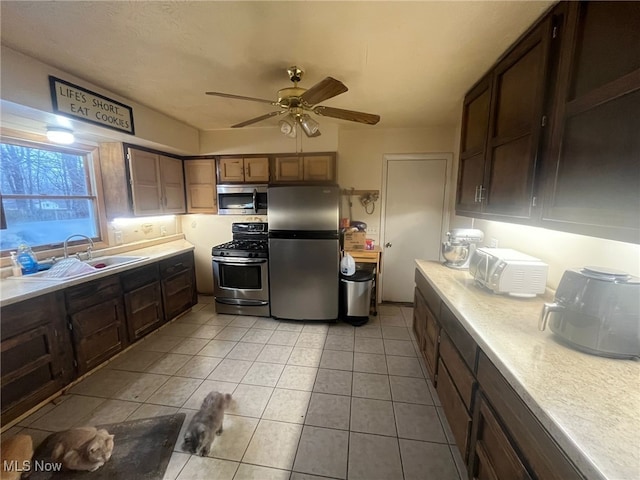 kitchen with ceiling fan, sink, light tile patterned floors, and stainless steel appliances