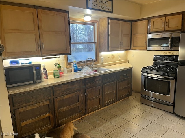 kitchen featuring light tile patterned floors, sink, and appliances with stainless steel finishes