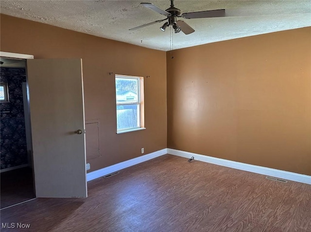 unfurnished room featuring a textured ceiling, ceiling fan, and dark wood-type flooring