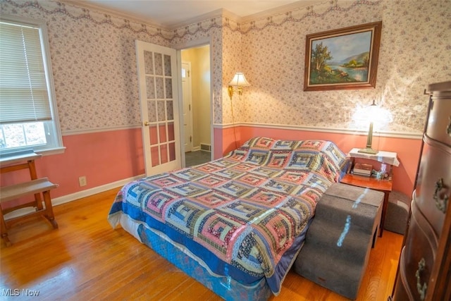 bedroom with crown molding and hardwood / wood-style floors