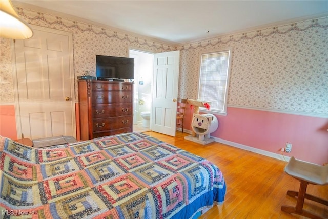 bedroom featuring ensuite bath, crown molding, and hardwood / wood-style flooring