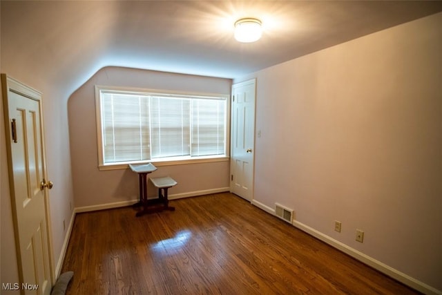 interior space with dark hardwood / wood-style floors and lofted ceiling