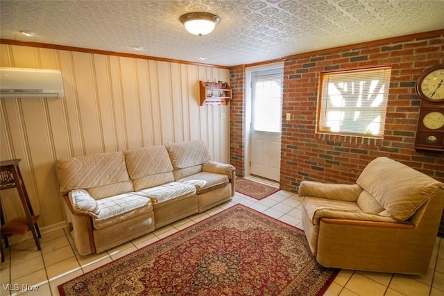 living room featuring light tile patterned flooring, a textured ceiling, a wall unit AC, and brick wall