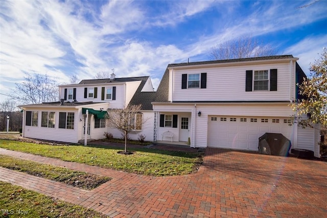 view of front of property featuring a garage and a front lawn