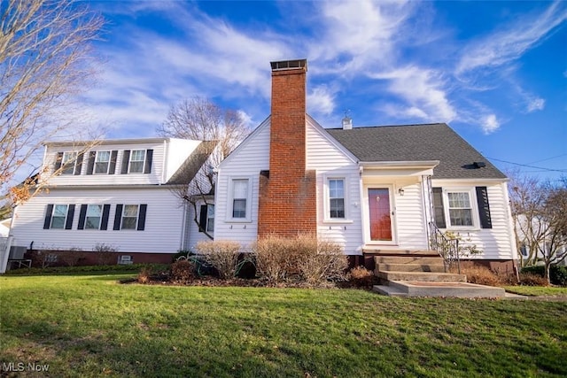 view of front of home featuring cooling unit and a front yard